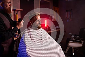 Haircut at the hairdresser, in salon. barber male cuts the hair on the handsome young client`s head