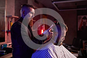 Haircut at the hairdresser, in salon. barber male cuts the hair on the handsome young client`s head