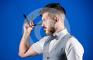 Haircuts and shaves. Bearded man with razor and scissors in retro barbershop. Hipster with beard in razor barber shop