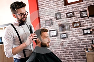 Hairdresser adjusts hair a customer with a comb