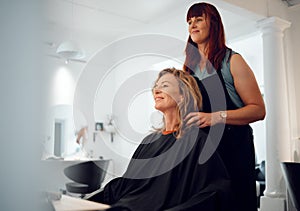 Hairdresser, beauty and senior happy customer at a salon for a makeover, lifestyle change in New York. Luxury, woman and