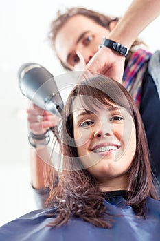 Hairdresser blow dry hair in shop