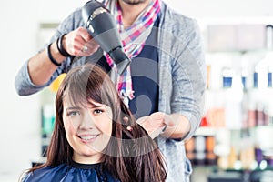 Hairdresser blow dry woman hair