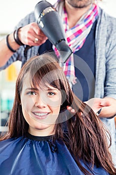 Hairdresser blow dry woman hair