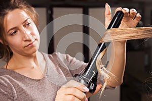 Hairdresser carefully making hair curling to a model