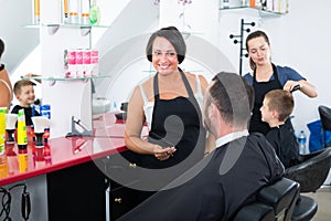 Hairdresser chatting to male client in beauty salon