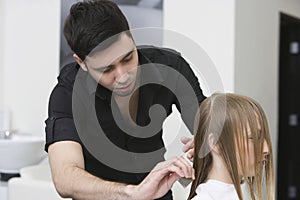 Hairdresser Combing Client's Hair Before Haircut At Parlor