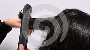 Hairdresser combing and curling a young girl`s hair