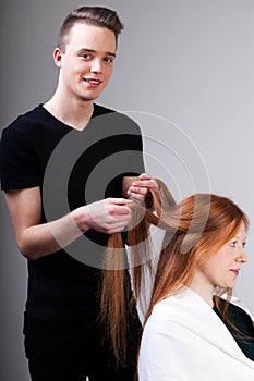 Hairdresser is combing customer hair