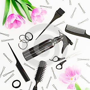 Hairdresser composition with spray, scissors, combs, barrette and tulips flowers on white background. Beauty concept. Flat lay, to