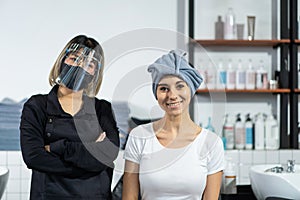 Hairdresser crossed arms, smiling and look at camera at beauty salon. Asian professional female hair stylist work by wash and