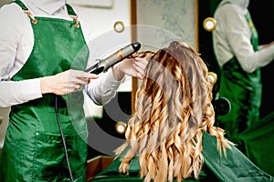 Hairdresser curling hair with curling iron