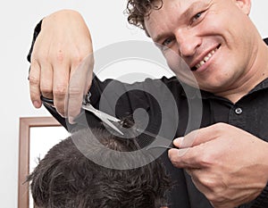 Hairdresser cuts men`s hair cut