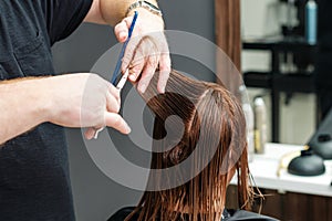 Hairdresser is cutting client`s hair in beauty salon