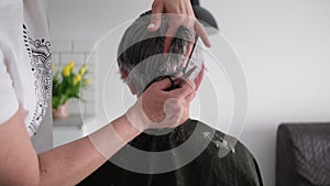 Hairdresser Cutting Gray Hair Of Senior Woman At Home