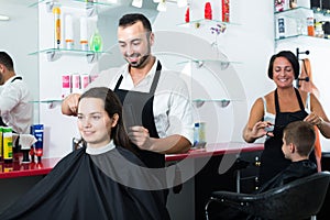 Hairdresser cutting hair of female client