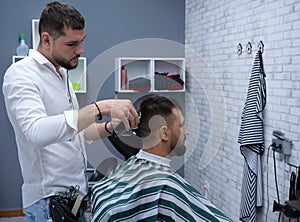 Hairdresser cutting hair with machine