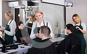 Hairdresser cutting hair of male