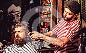 Hairdresser cutting hair of male client. Hairstylist serving client at barber shop. Man visiting hairstylist in