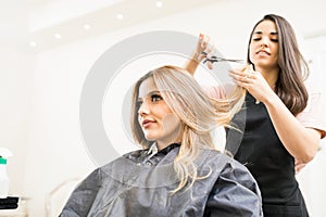 Hairdresser cutting some hair tips