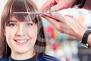 Hairdresser cutting woman bangs hair