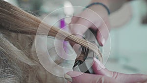 Hairdresser does a haircut - curls, using a curling iron