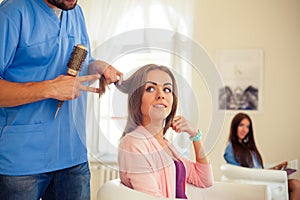 Hairdresser doing haircut for women in hairdressing salon. Concept of fashion and beauty. Positive emotion.