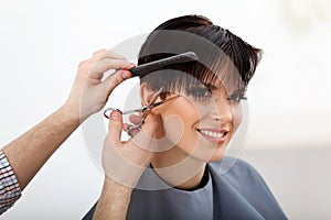 Hairdresser doing Hairstyle. Brunette with Short Hair in Salon photo