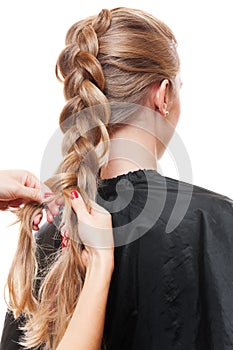 Hairdresser doing up one's hair in a plait