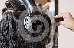 The hairdresser dries her hair a brunette girl in a beauty salon