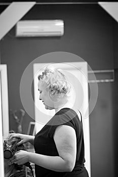 Hairdresser drying hair with hand dryer