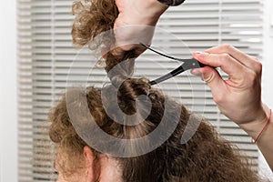 Hairdresser fastens hair with a hair clip for proper long hair cutting