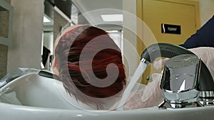 Hairdresser in gloves washes hair close-up