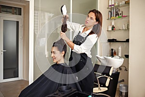 Hairdresser and happy woman, hairdressing salon