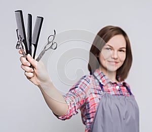 Hairdresser holding various combs and scissors