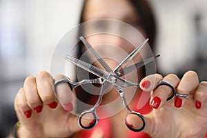 Hairdresser holds working scissors with comb in his hands