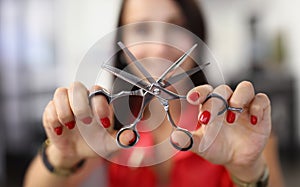 Hairdresser holds working scissors with comb in his hands