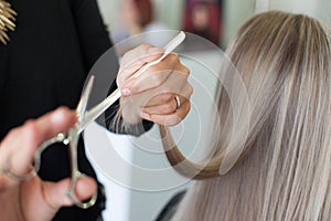 Hairdresser makes the hair cut the girl with long hair