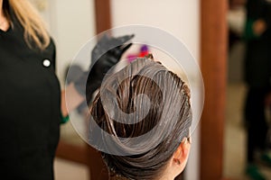 Hairdresser making hair treatment to a customer in salon