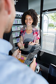 Hairdresser with male client paying with credit card