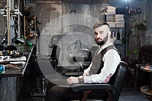 Hairdresser man shaves a client with a beard in a barbershop