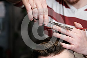 Hairdresser man shaves a client with a beard in a barbershop