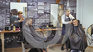 Hairdresser for men. Barbershop. Caring for the beard. Barber with hair clipper works on hairstyle for bearded guy