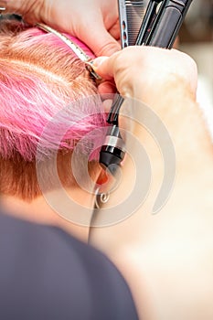 Hairdresser pinches hair with clip