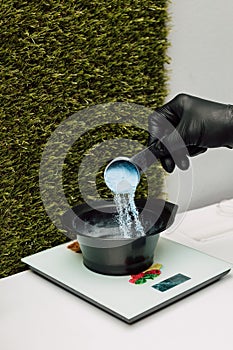 A hairdresser pours an oxidizer. The process of preparation before coloring hair