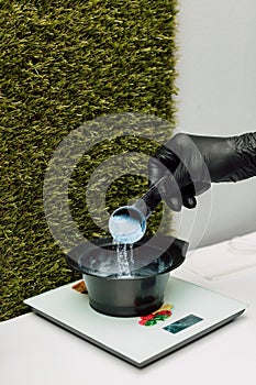 A hairdresser pours an oxidizer. The process of preparation before coloring hair