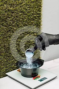 A hairdresser pours an oxidizer. The process of preparation before coloring hair