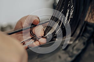 hairdresser's hands cutting wet hair with scissors and comb