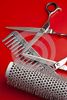 hairdresser`s tool scissors, comb on a red background