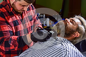 Hairdresser salon. Professional barber and client. Barber is essential resource for your style. Shaving with razor